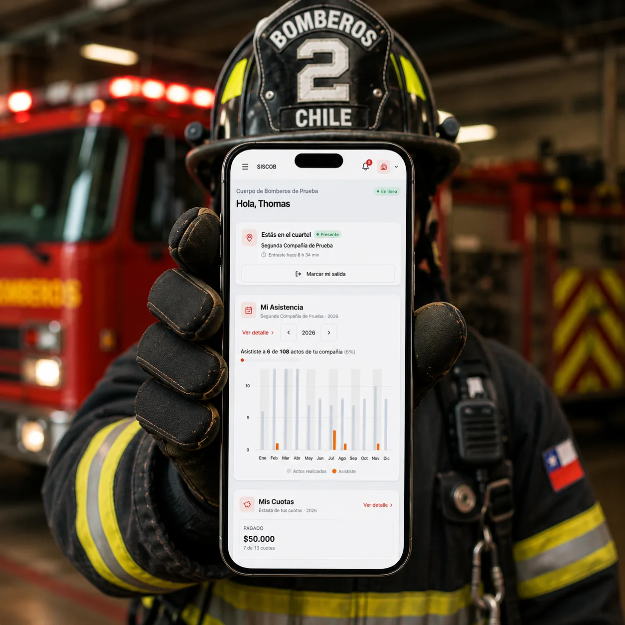 Bombero de un Cuerpo de Bomberos chileno con SISCOB abierto en su teléfono, frente a los carros del cuartel.